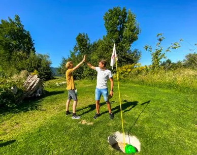 Zwei Erwachsene an einem Fußballgolf-Ziel auf der Anlage im Rosental
