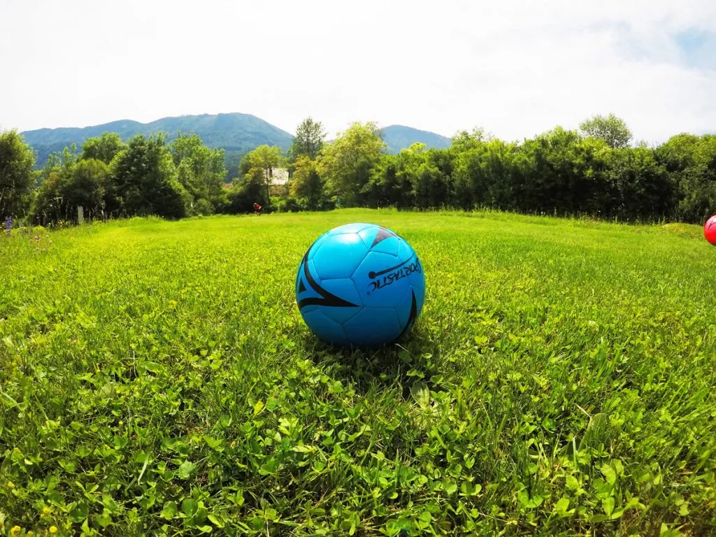 Blauer Fußball auf einer sonnigen Bahn der Kick2Gether-Anlage